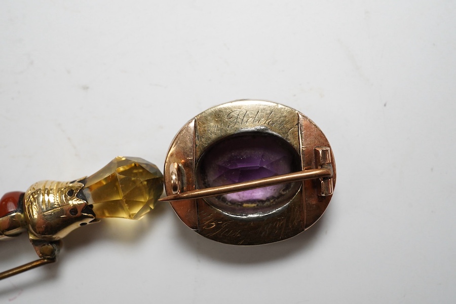 An early 20th century yellow metal, gem and Scottish hardstone set dirk brooch, 55mm, together with a George IV yellow metal, amethyst and split pearl set oval mourning brooch. Condition - poor to fair